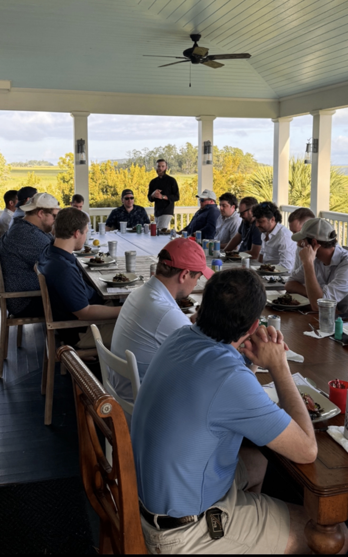 Chef Kurt addressing guests at an outdoor low-country dinner